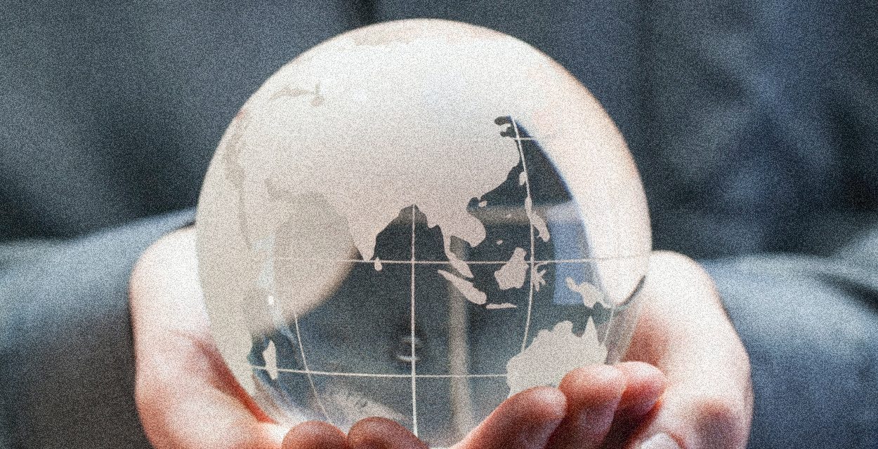 Hands Holding Glass Globe with Blue in the Background | Zero Population Growth Isn’t the Answer | Public Square Magazine | Zero Population Growth Movement