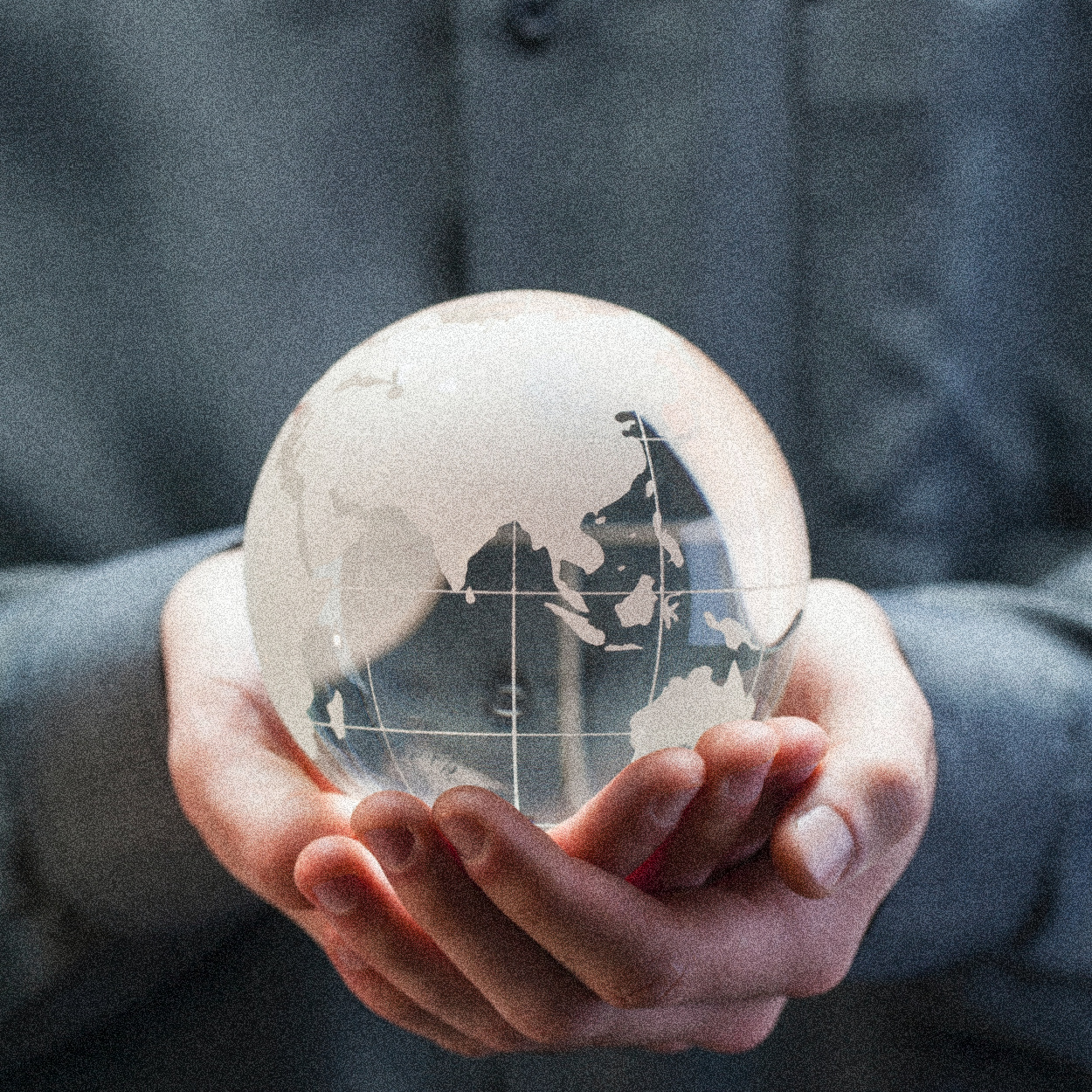 Hands Holding Glass Globe with Blue in the Background | Zero Population Growth Isn’t the Answer | Public Square Magazine | Zero Population Growth Movement