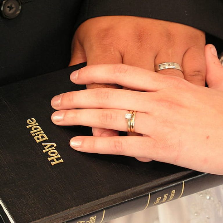 Marital fidelity intertwined with faith represented by Bible and wedding rings.