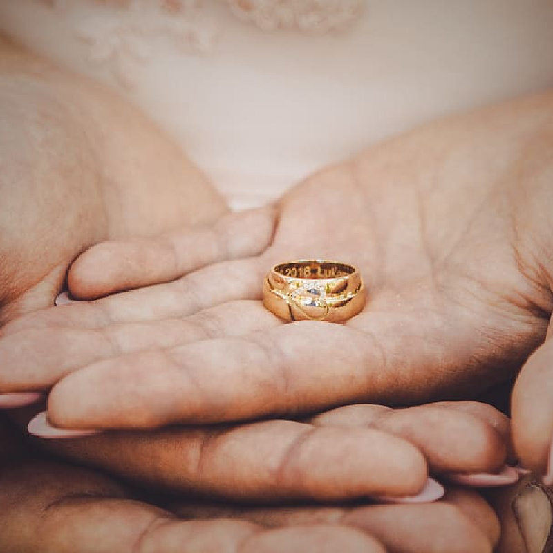 Close-up of hands holding a wedding ring, symbolizing the sacred commitment of marriage and the law of chastity.