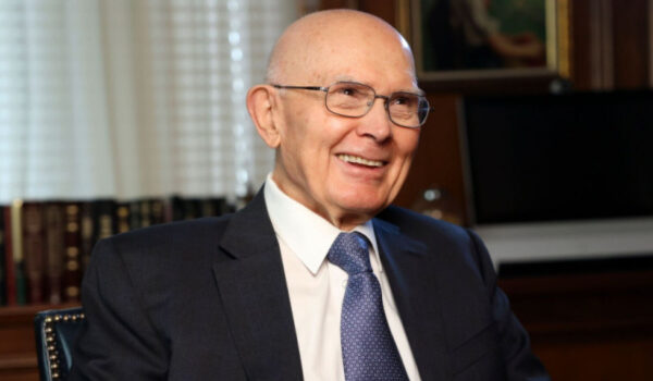 President Dallin H. Oaks seated, smiling gently, wearing a dark suit and tie in an office setting