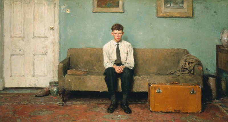 An early returned missionary sits alone in a quiet living room beside a suitcase.