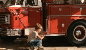 A boy polishing a fire engine. 9/11 hero Welles Crowther helped in his father’s fire station as a boy, which helped form his heroic character.
