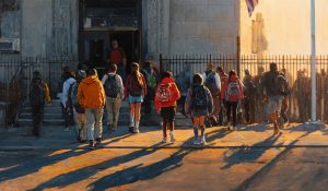 Students gather outside a public school entrance, representing Religion in public schools and civic pluralism.