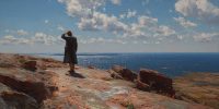  A man stands alone on a rocky coast looking out at the sea. Hope in hard times as deliverance appears small but real.