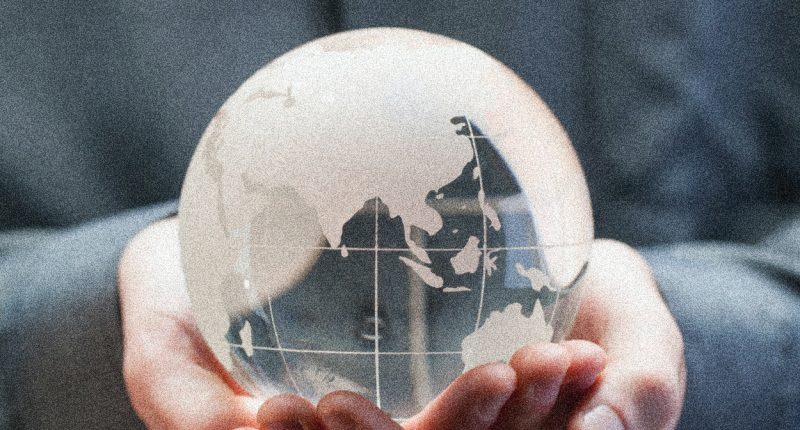 Hands Holding Glass Globe with Blue in the Background | Zero Population Growth Isn’t the Answer | Public Square Magazine | Zero Population Growth Movement