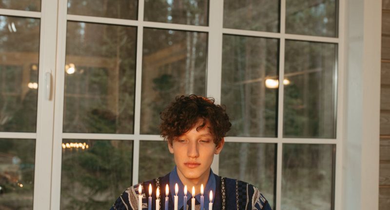 Man in Sweater Holding a Menorah | Joseph Smith, Harold Bloom, & Jewish Gnosticism | Public Square Magazine | Harold Bloom Gnosticism | Harold Bloom Religion & Mormon Gnosticism